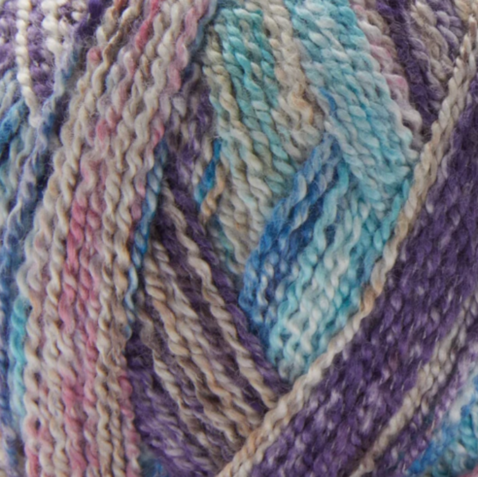 Close-up image of multi-colored yarn alongside a knit up swatch in the colors tan blue purple pink