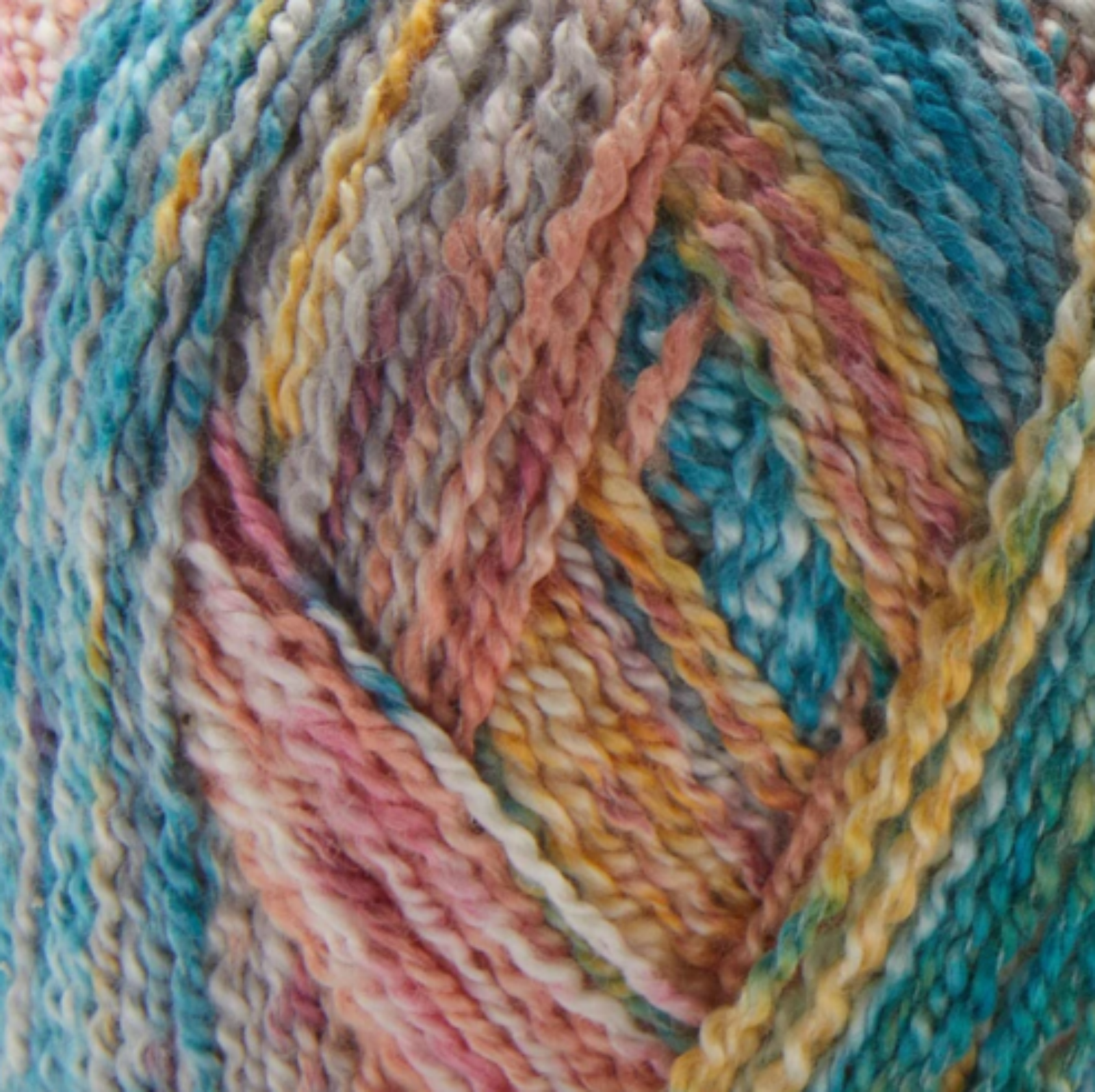 Close-up image of multi-colored yarn alongside a knit up swatch in the colors green red orange yellow grey