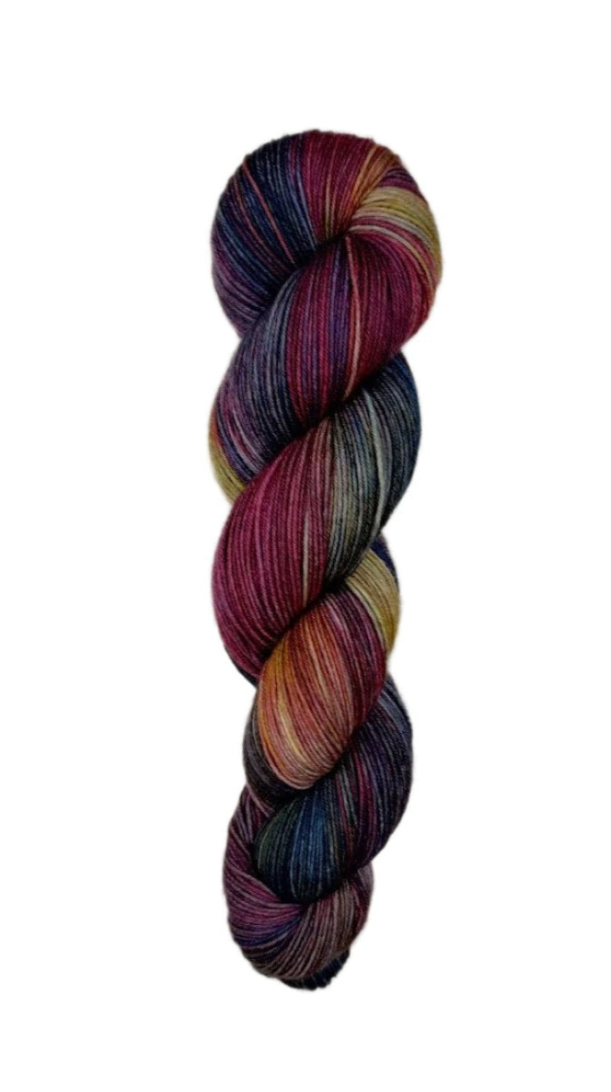 A skein of hand-dyed fingering/sock yarn color tan burgundy navy black 