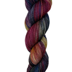 A skein of hand-dyed fingering/sock yarn color tan burgundy navy black 