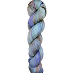 A skein of hand-dyed fingering/sock yarn color grey periwinkle brown peach brown speckles