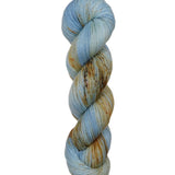 A skein of hand-dyed fingering/sock yarn color blue tan orange brown speckles