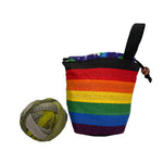 Rainbow striped yarn bag with a ball of yarn on a white background