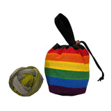 Rainbow striped bag with a black handle next to a ball of yarn on a white surface