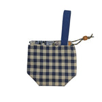 Blue and white checkered pouch with a blue strap on a beige background