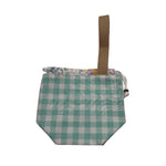 A small fabric drawstring pouch with a teal and white gingham pattern, a floral patterned trim along the top, and a tan webbing loop handle.