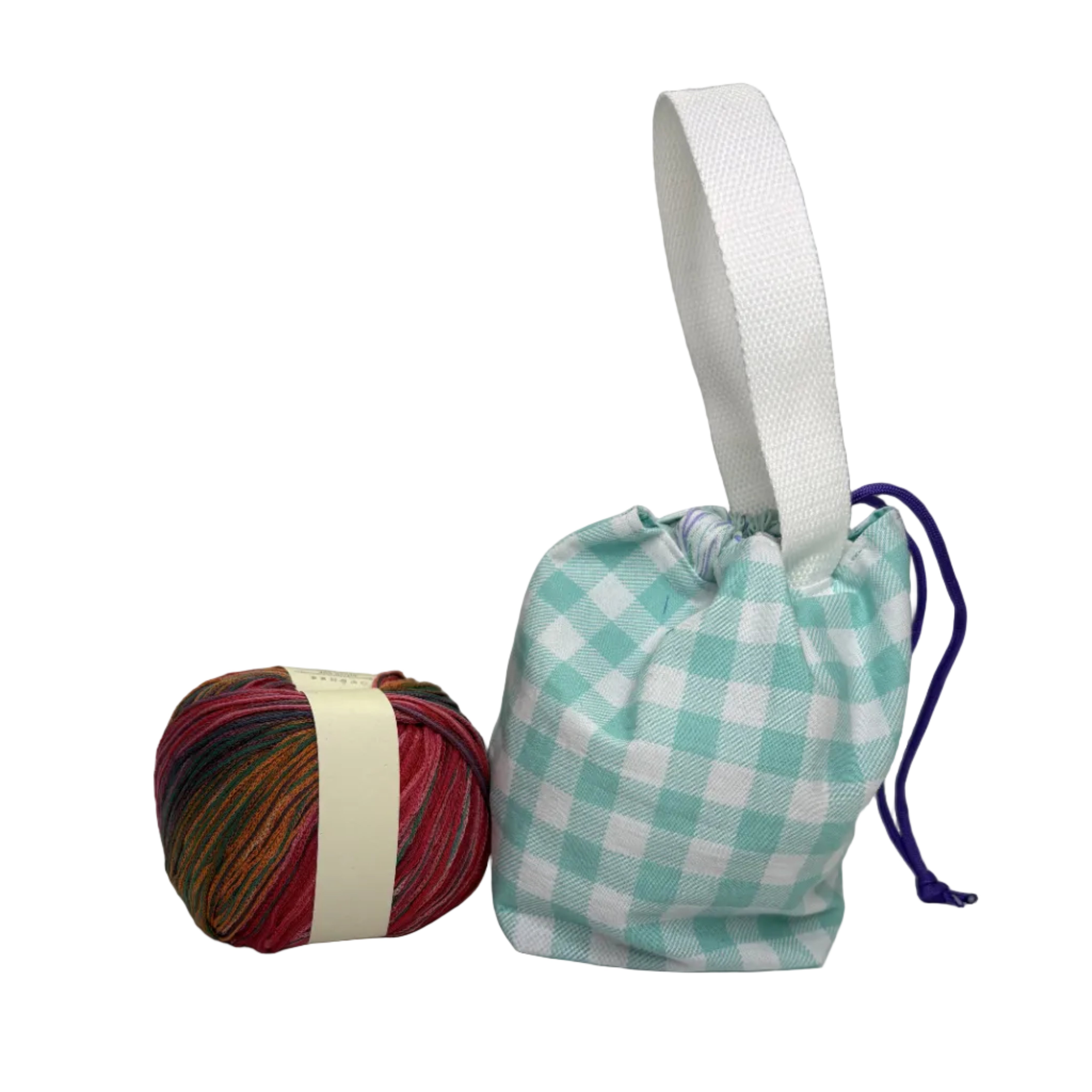 A small fabric drawstring pouch with a teal and white gingham pattern, a white webbed handle, and a purple drawstring cord, displayed next to a ball of multicolored yarn 