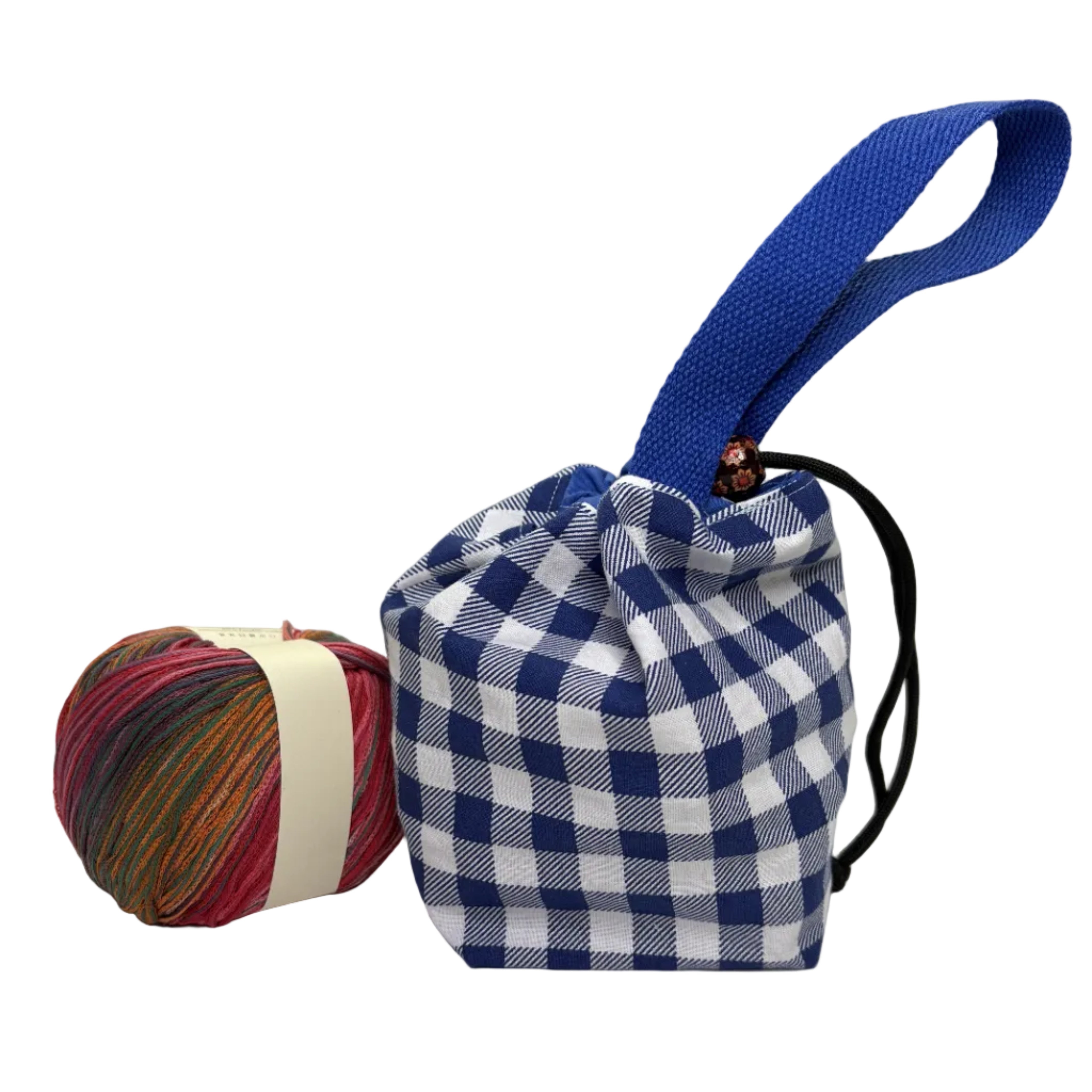 A small fabric drawstring pouch with a blue and white gingham check pattern, a blue webbed handle, and a black drawstring cord, displayed next to a ball of multicolored yarn 