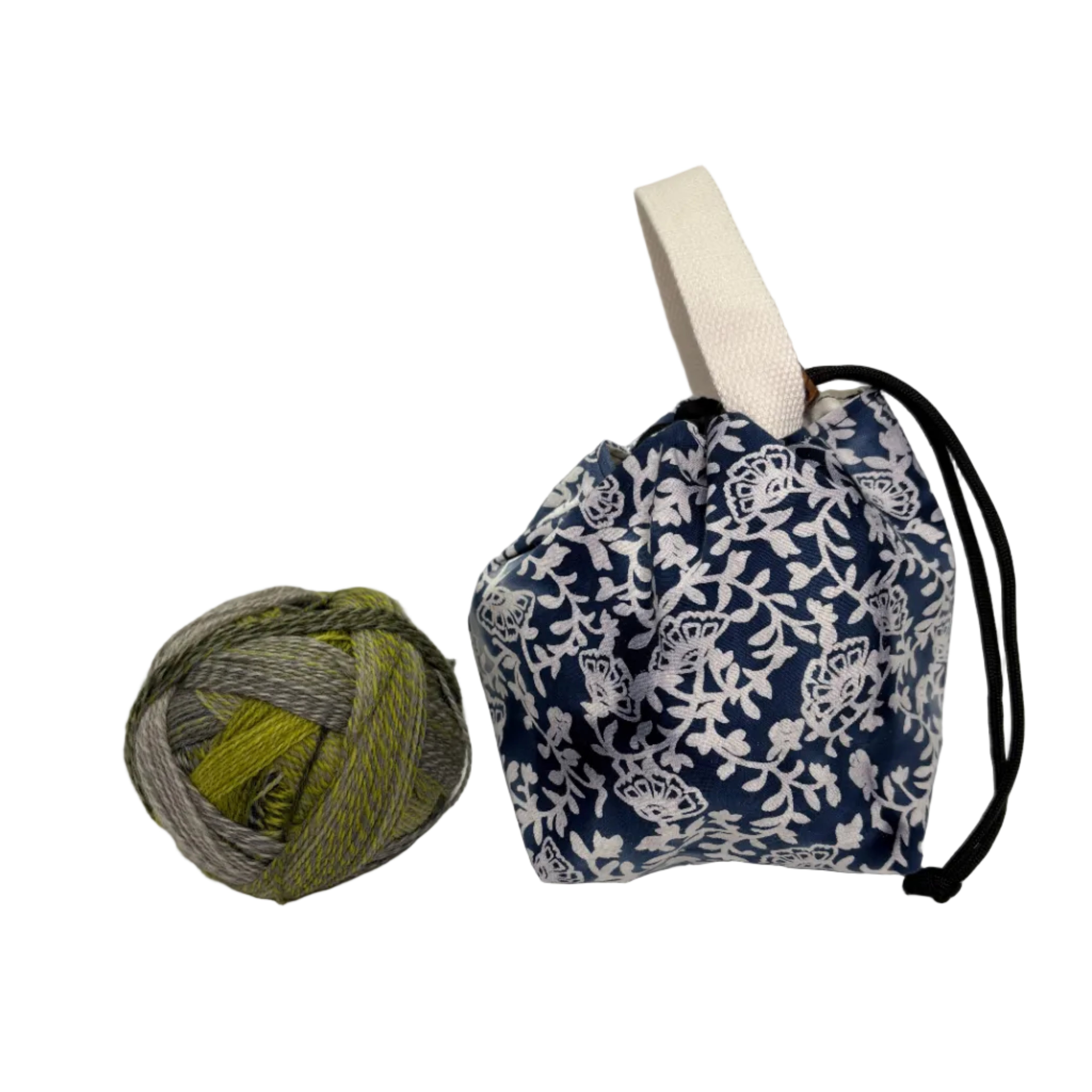 Yarn ball next to a blue and white floral patterned drawstring bag on a white background