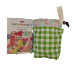 Green checkered pouch with pink flamingo design on a white surface, next to a book titled 'The Sock Project'.