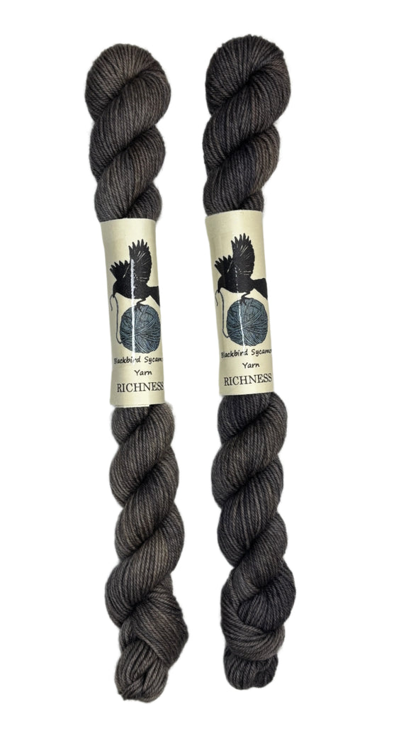 Mini skeins of hand dyed fingering weight yarn in the color dark grey