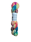 A skein of hand-dyed fingering/sock yarn color yellow pink blue purple teal speckles