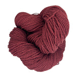 A ball of Mountain Meadow Wool Yarn in the color deep rust red
