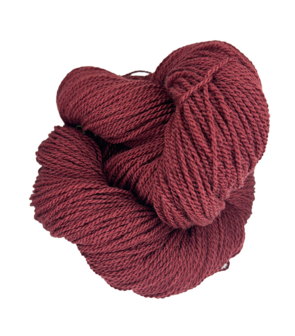 A ball of Mountain Meadow Wool Yarn in the color deep rust red