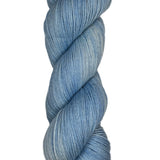Skein of hand dyed fingering weight yarn in the color sky blue