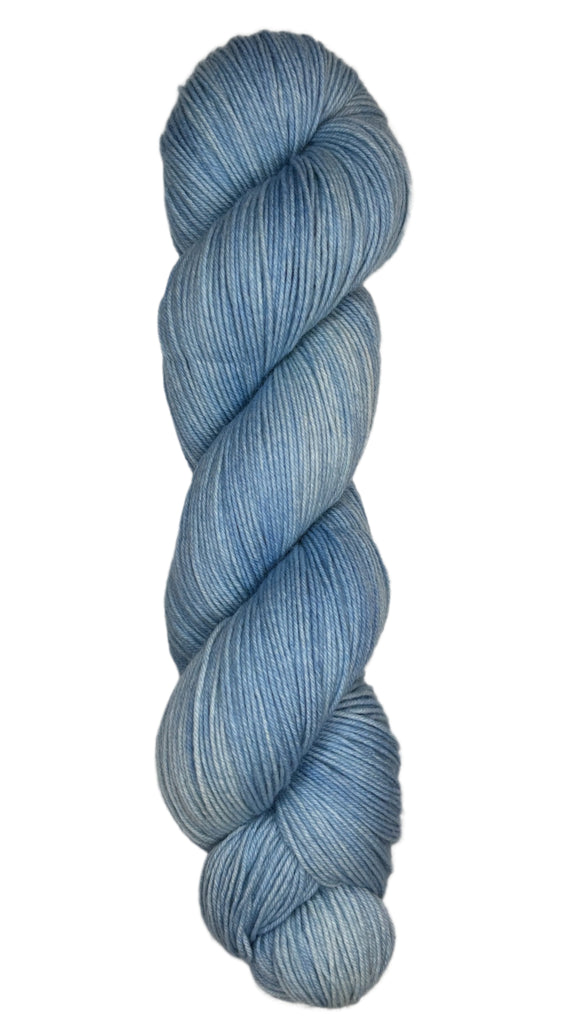 Skein of hand dyed fingering weight yarn in the color sky blue