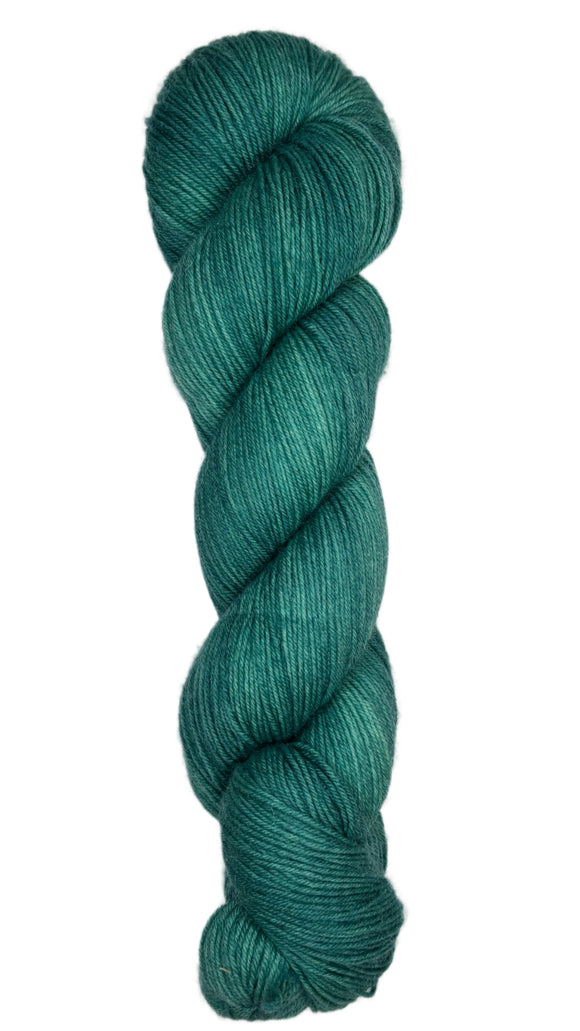 Skein of hand dyed fingering weight yarn in the color spruce green