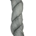 Skein of hand dyed fingering weight yarn in the color grey