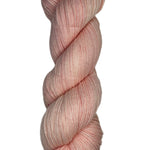 Skein of hand dyed fingering weight yarn in the color light pink
