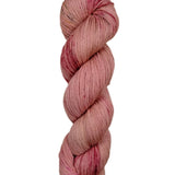 A skein of hand-dyed fingering/sock yarn color pink red brown speckles