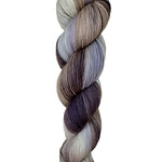 A skein of hand-dyed fingering/sock yarn color white grey tan blue brown