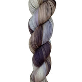 A skein of hand-dyed fingering/sock yarn color white grey tan blue brown