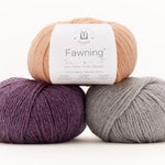 Balls of Universal Yarn Fawning DK weight yarn in the colors purple grey and peach