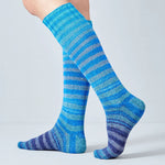 Blue striped socks worn by a person on a light gray background