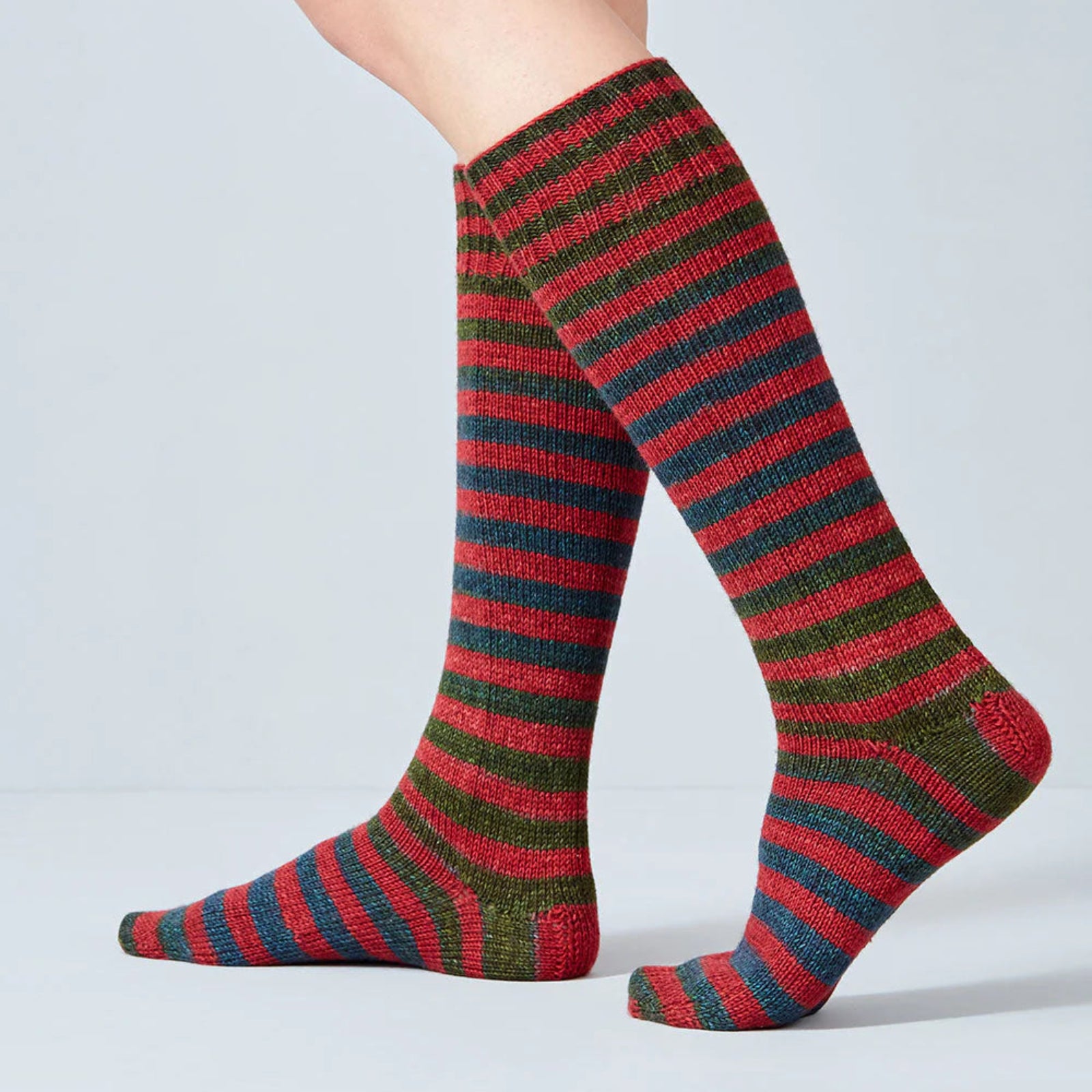Red and green striped socks on a plain background
