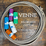 Spools of weaving organic cotton on a wooden shelf