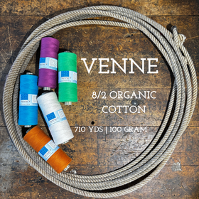 Spools of weaving organic cotton on a wooden shelf