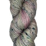 A skein of wool yarn in a light grey color with streaks of pink and dark blue speckles