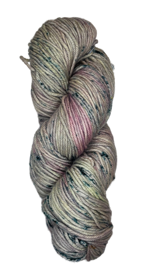 A skein of wool yarn in a light grey color with streaks of pink and dark blue speckles