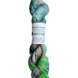 A skein of hand-dyed fingering/sock yarn color grey neon green forest green orange brown black speckles