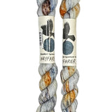 Two mini skeins of wool yarn hand dyed in Wyoming in the color grey blue orange speckles