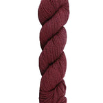 Burgundy skein of mountain meadow wool yarn on a white background