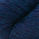 A close-up of textured yarn with a variegated colorway of deep navy, purple, and bright teal blue.