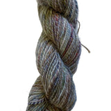 A twisted skein of variegated yarn in muted earthy tones of gray, beige, brown, and hints of blue and purple, photographed on a plain off-white background.