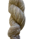 A single skein of soft, twisted yarn in a heathered blend of beige, taupe, and light brown tones, photographed against a plain white background.