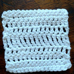 A white crocheted coaster that will be made during the begin to crochet class