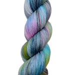 A skein of hand-dyed fingering/sock yarn color grey blue pink green black