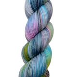 A skein of hand-dyed fingering/sock yarn color grey blue pink green black