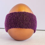 A purple knitted headband displayed on a glossy gold mannequin head against a plain light background.