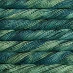Close-up of twisted yarn skeins in a variegated blend of deep teal, forest green, and soft sage green.