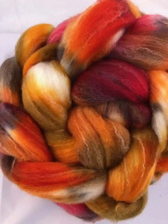 a braid of ready to be spun fiber color orange red brown