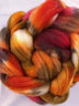 a braid of ready to be spun fiber color orange red brown