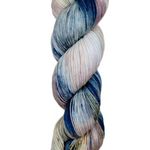 A skein of hand-dyed fingering/sock yarn color pink white blue brown speckles