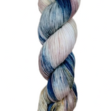 A skein of hand-dyed fingering/sock yarn color pink white blue brown speckles