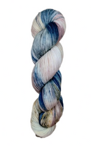 A skein of hand-dyed fingering/sock yarn color pink white blue brown speckles