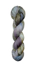 A skein of hand-dyed fingering/sock yarn color white grey tan blue purple black speckles